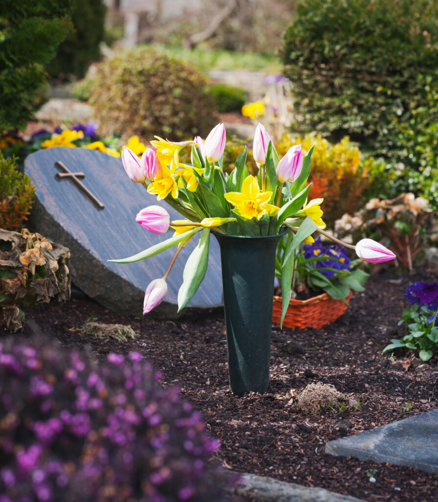 Fleurissement de tombes. Vase élégant contenant un bouquet printanier de tulipes et de jonquilles.